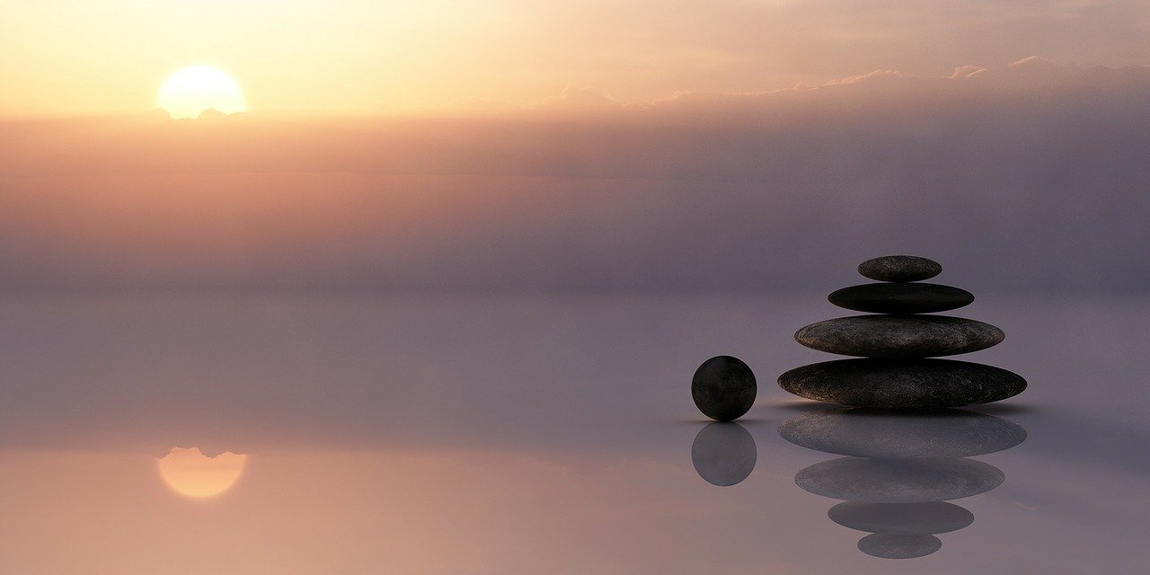 Rocks piled on top of one another on the beach at sunset